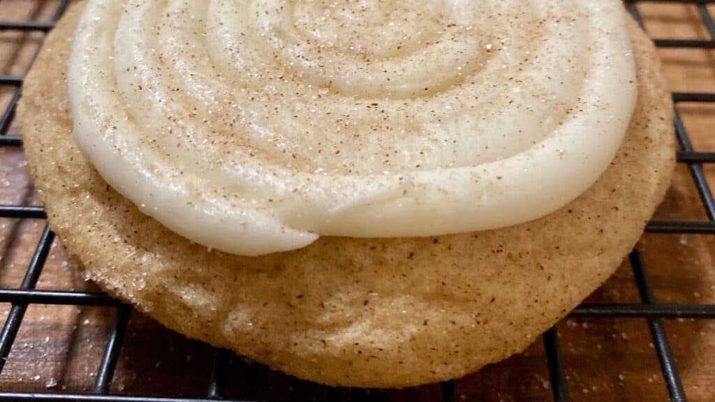 Crumbl Snickerdoodle Cupcake Cookie with frosting on wire mesh