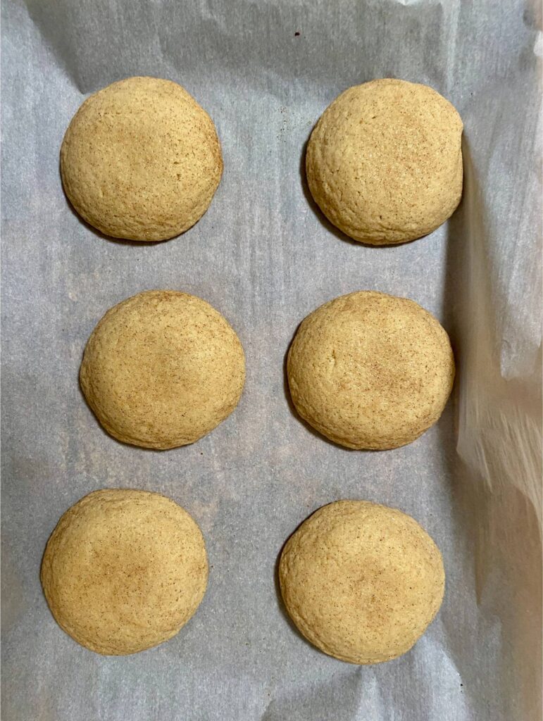 Crumbl Snickerdoodle Cupcake Cookie dough balls flatten on parchment paper