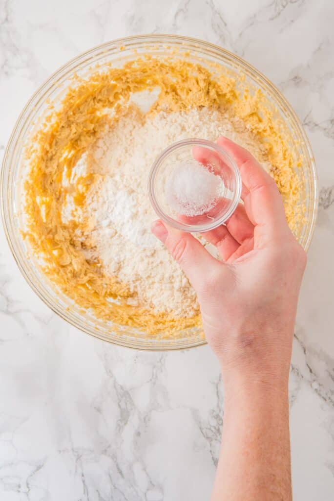 Add baking powder to wet mixture of Cranberry Orange Cookies in a bowl