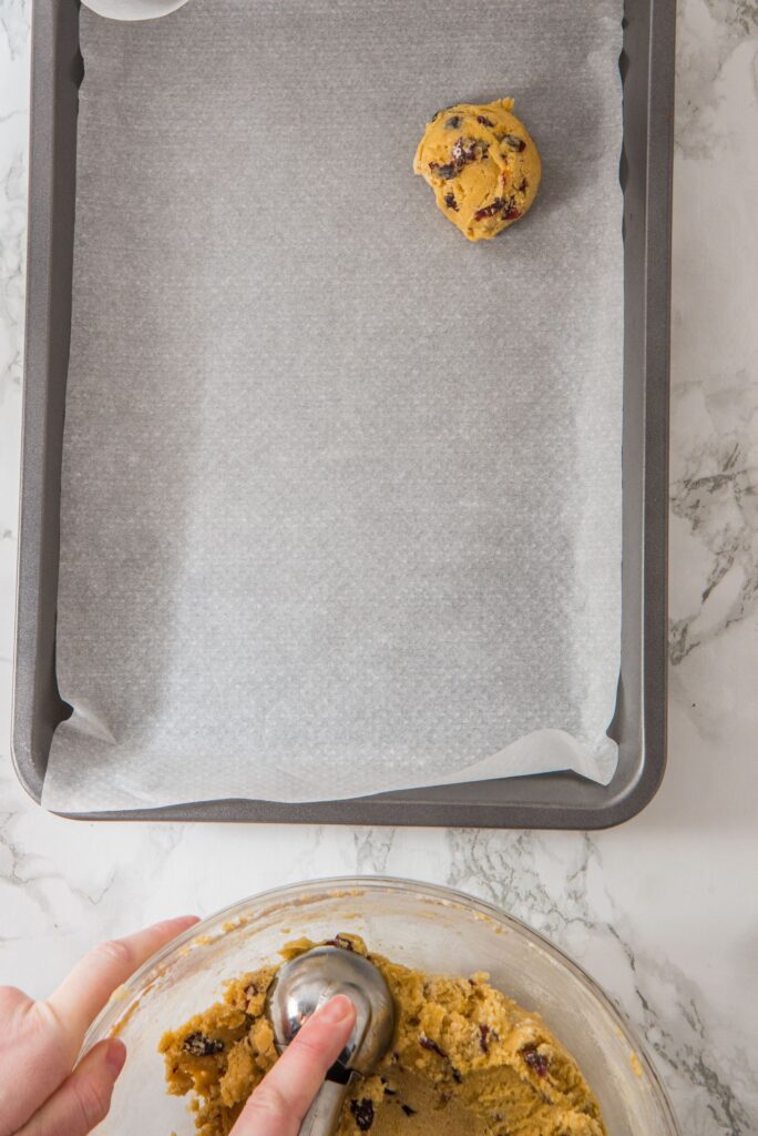 Cranberry Orange Cookie dough balls in baking sheet with parchment paper