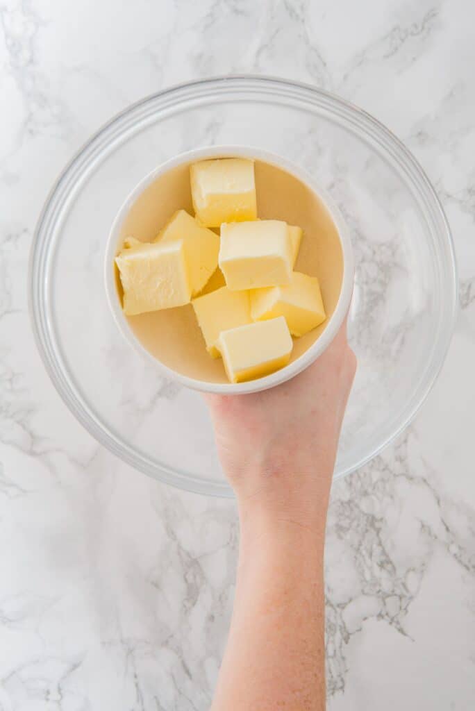 Adding butter cubes to a large bowl
