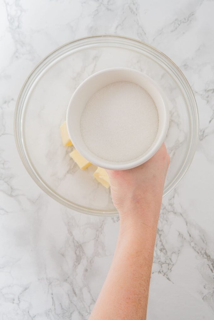 Adding sugar to a large bowl