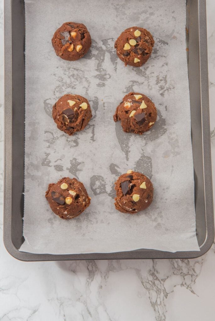 Fudgy Triple Chocolate Chip Cookies dough balls on baking tray