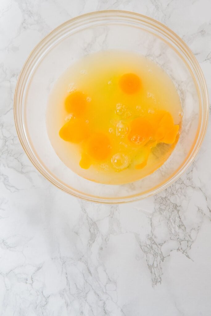 In a bowl, add the eggs, yolks, lemon juice