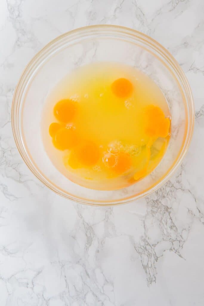 In a bowl, add the eggs, yolks, lemon juice,