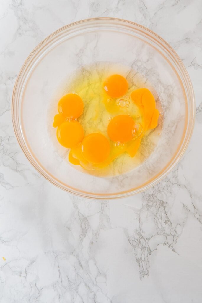 In a bowl, add the eggs and yolks