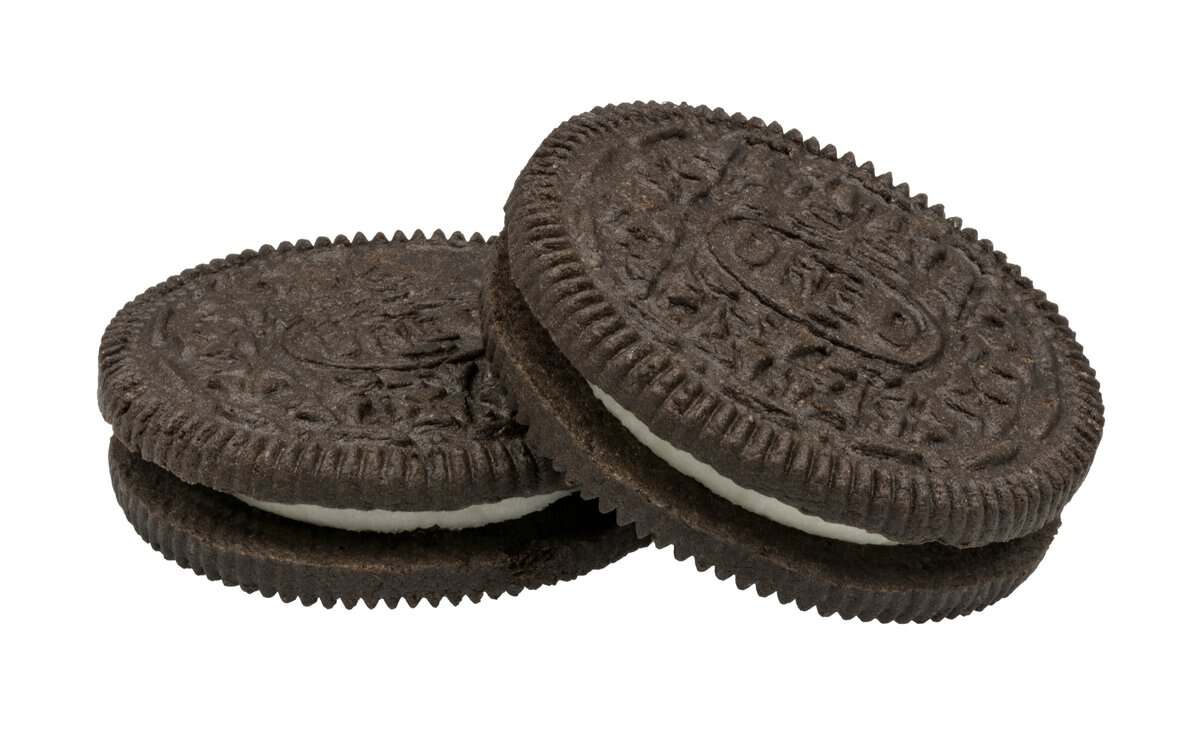 Two classic Oreo sandwich cookies, chocolate wafers with the embossed Oreo pattern, one stacked leaning against the other on a white background.