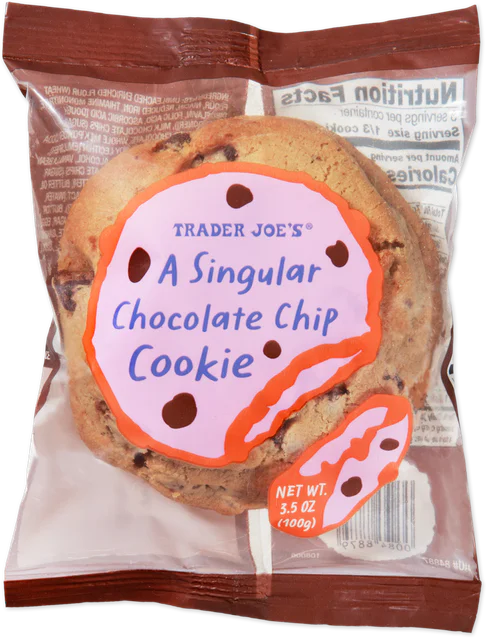 A Trader Joe's A Singular Chocolate Chip Cookie in its clear single-serve package, with a pink and orange label reading Trader Joe's A Singular Chocolate Chip Cookie, net wt. 3.5 oz (100 g), and the nutrition facts showing through the back.